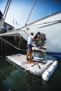 Man cleaning yacht from inflatable maintenance platform - Nautibuoy Marine